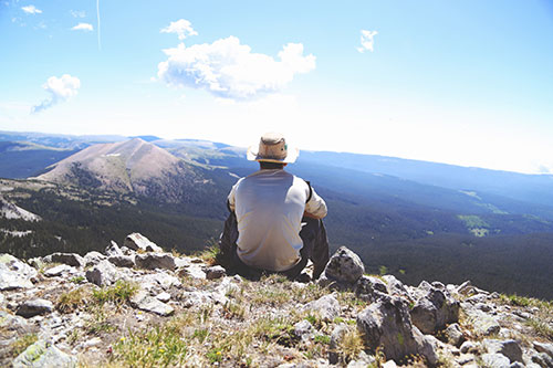 Individual on a mountain with back turned